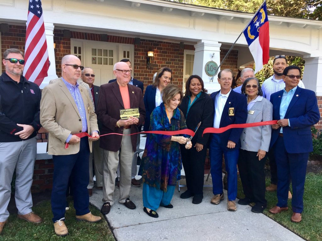 Richard Monroe, holding Chamber of Commerce Plaque, stands next to Nila chamberlain at the ribbon cutting. Grand Opening Robeson Art Guild, October 28, 2021